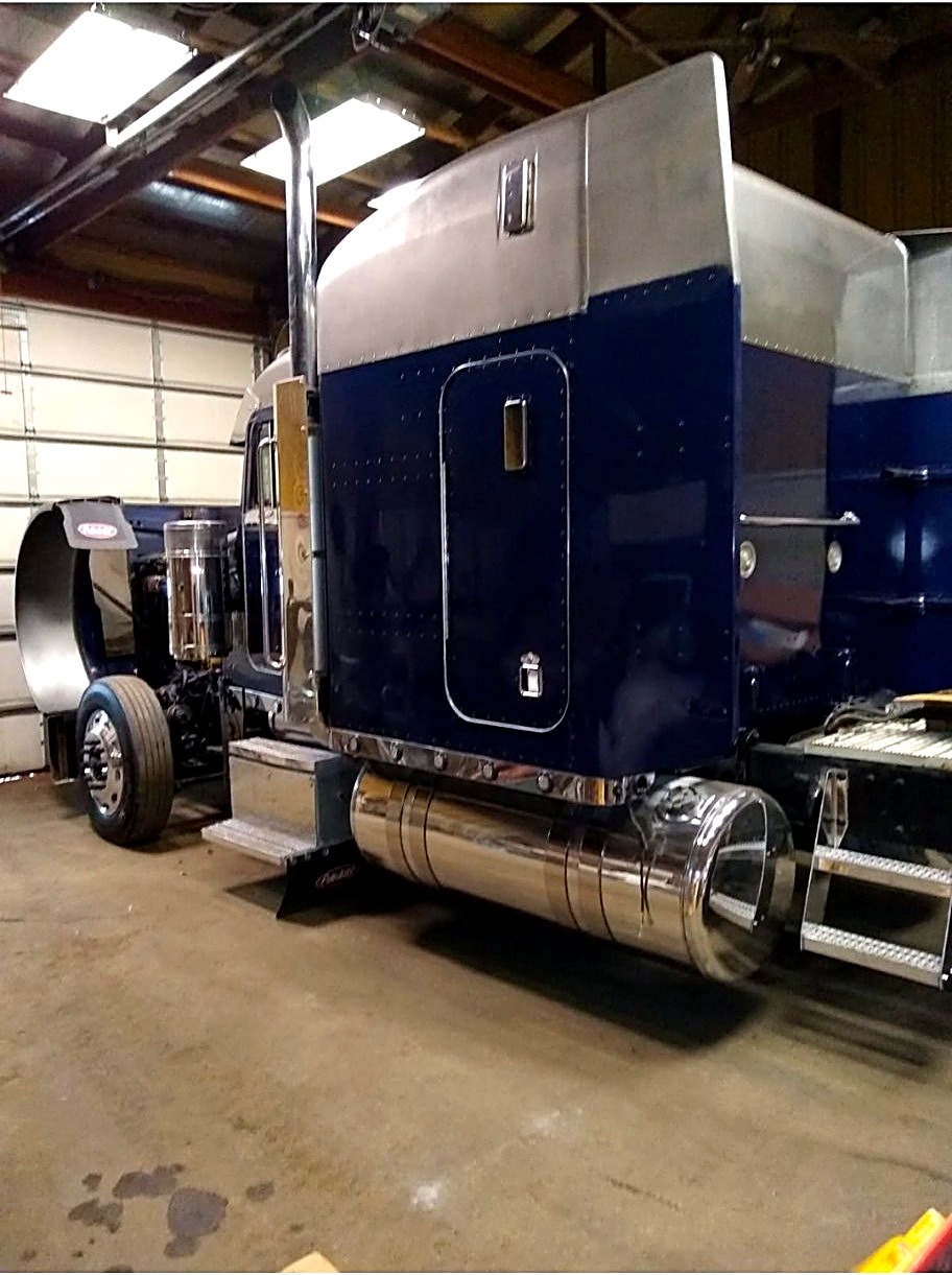 Dark blue Peterbilt semi inside the shop